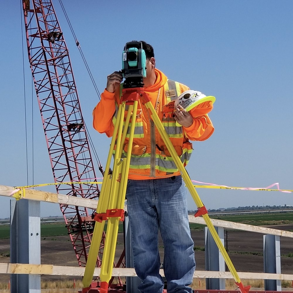 Construction worker looking into a levelling tool