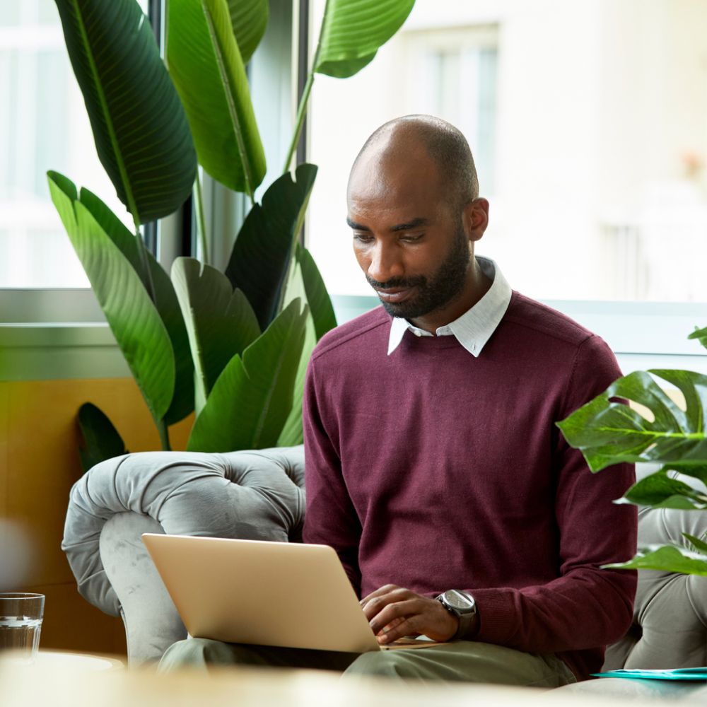 Un homme assis utilisant un ordinateur portable