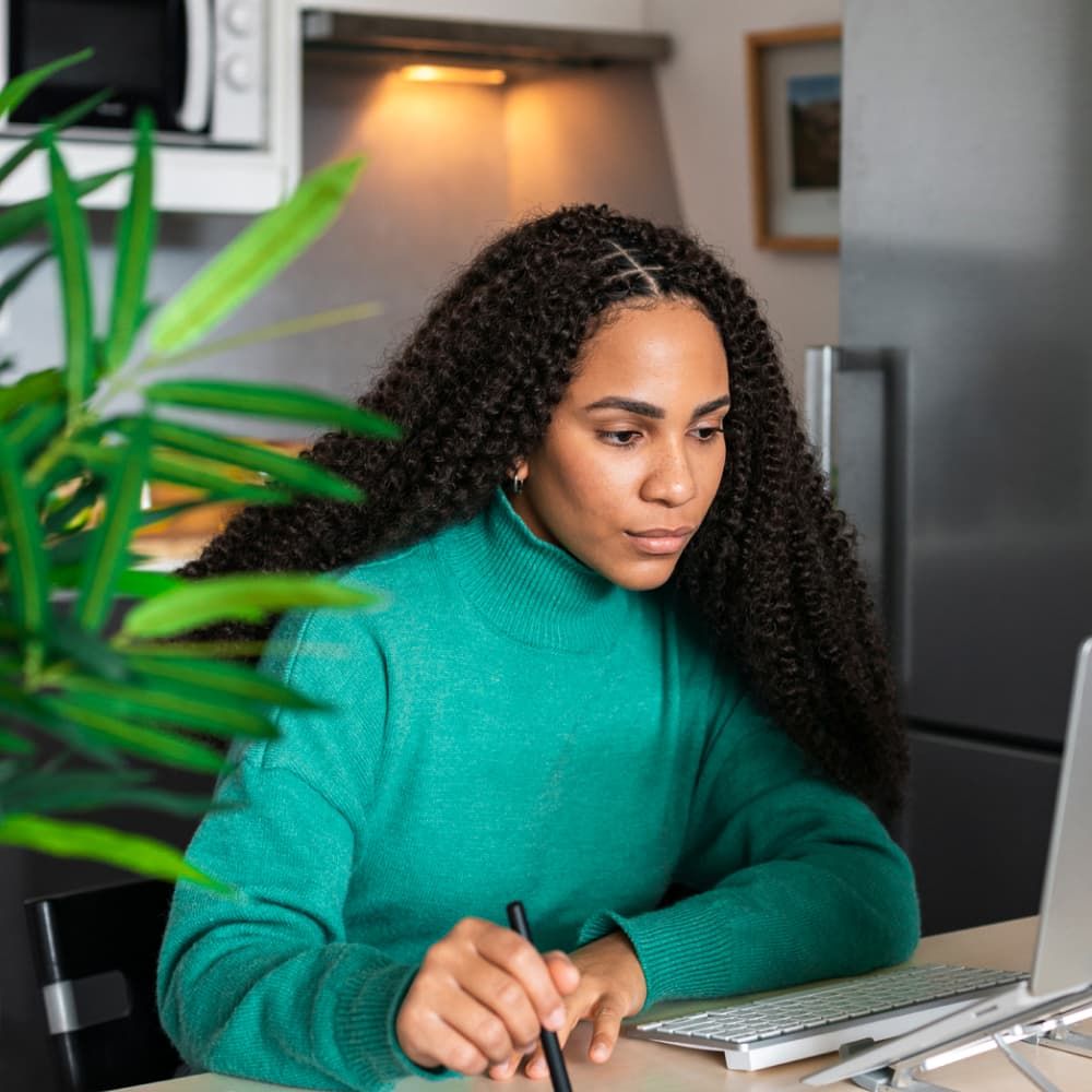 Personne assise à un bureau qui regarde son ordinateur