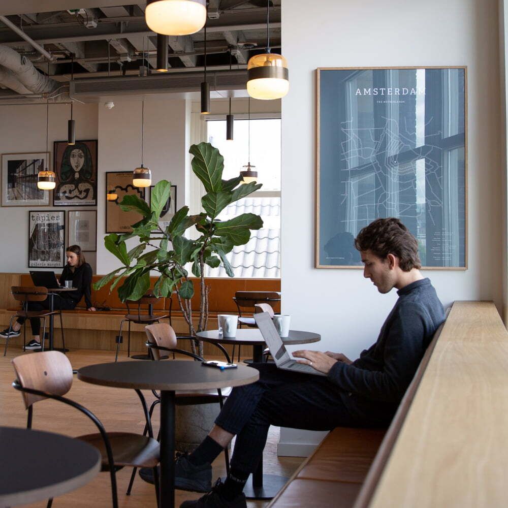 Homme travaillant sur un ordinateur portable dans un café